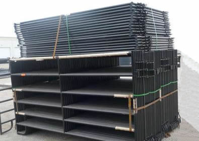 Many black powder coated fence panels packed 