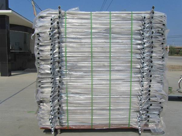 A metal pallet of crowd control barriers in the yard.