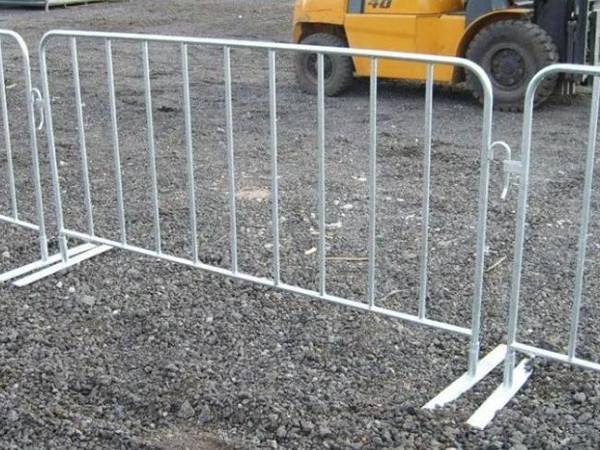 several hot dipped galvanized crowd control barriers are surrounding construction sites.